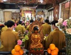 A group of people in a room with a statue of a buddha

Description automatically generated